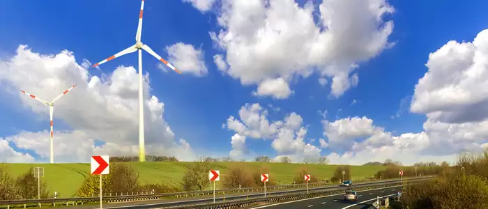 Straße mit Windrädern im Hintergrund